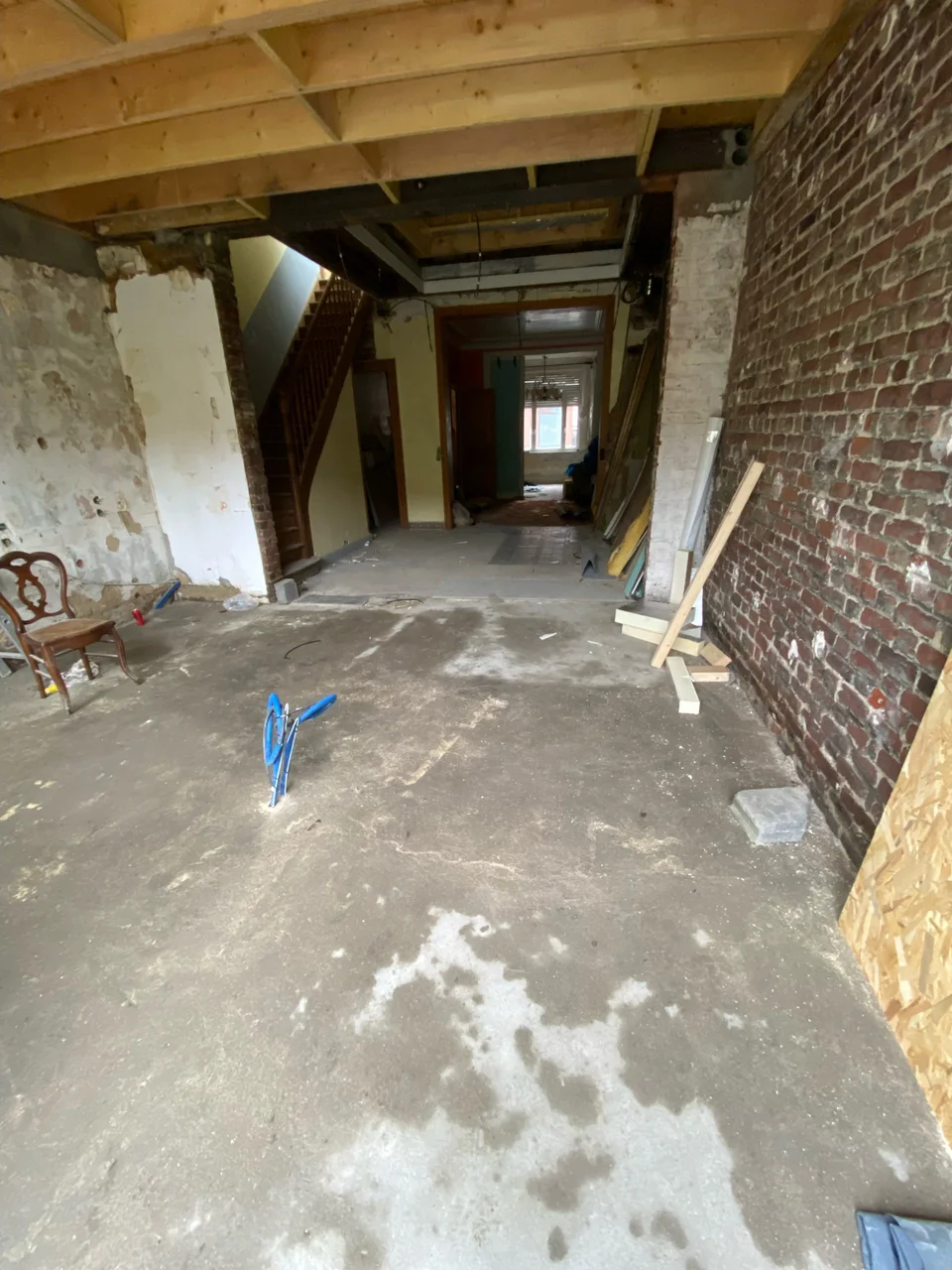 Rénovation clé en main d'une maison de 1908 à La Madeleine - pendant les travaux, le salon et le mur de brique